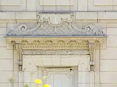 Photographie en couleurs du linteau en pierre gravée d'une porte.