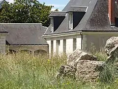 Photographie en couleurs d'un bâtiment à rez-de-chaussée et combles.