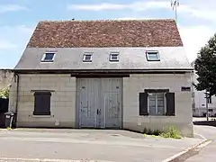 Photographie en couleurs d'un bâtiment asse ancien percé de baies modernes.