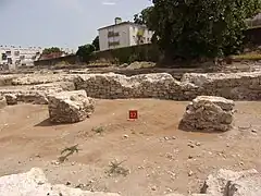 Photographie en couleurs d'une pièce dont les murs sont arasés à faible hauteur avec des massifs de maçonnerie au centre