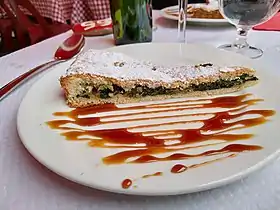 Une part de tourte de blettes sucrée dans une assiette.