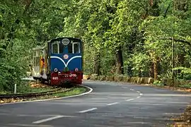 Une train tiré par une locomotive diesel sur les bords d'une route