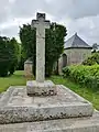 Le calvaire situé à l'entrée du placître de la chapelle de Trébalay, avec son Christ en méplat.