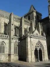 Photographie d'un porche monumental appuyé sur une nef d'église