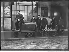 Tracteur électrique tirant des chariots dans une gare (1920).