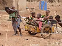 Femme du Bénin transportant des enfants (2020).