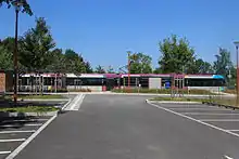 Vue de la nouvelle gare de la Chapelle-Aulnay avec parking, halte et tram-train à quai.