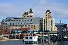 Une rame de tramway de la ligne T3b franchit le pont du canal de l'Ourcq devant les Grands Moulins de Pantin.