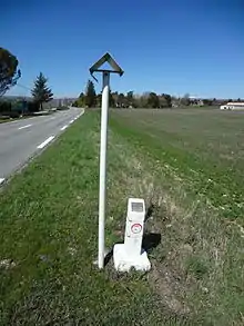 La conduite souterraine d’éthylène est indiquée par un potelet blanc dépassant du sol de 40 centimètres environ, et un poteau blanc plus haut coiffé d’un chapeau métallique.