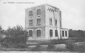 Photo noir et blanc montrant un bâtiment trapu neuf avec des fenêtres rectangulaires.