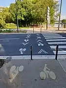 Traversée cycliste séparée du passage piétons en rive droite du pont avec marquages au sol non conformes