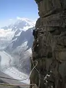 Traversée dans la voie Contamine en face Sud des Drus. Au second plan, la dent du Requin et en fond de tableau, le mont Blanc.