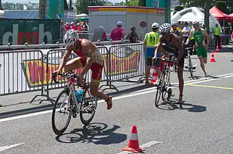 Transition une, des triathlètes montent sur leur vélo.