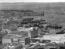 photographie noir et blanc : un port avec de grands navires à voiles