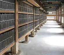 Photographie de l'intérieur d'un bâtiment ancien, avec des rayonnages remplis de livres anciens.