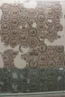 Vue d'une mosaïque présentée en position verticale, avec des motifs intégrés dans des médaillons