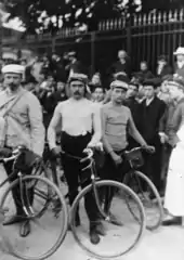 Photographie de coureurs se tenant debout à côté de leur vélo.