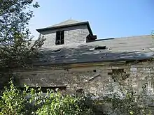 Photographie d'un détail d'un bâtiment montrant son état, en ruine