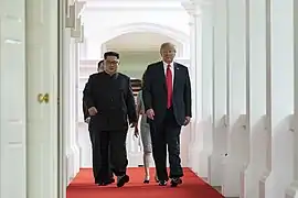 Kim Jong-un et Donald Trump marchant vers la salle du sommet.