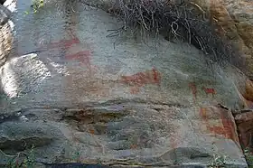 Animaux à cornes, dessinés en ocre sur une paroi rocheuse