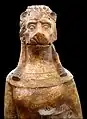 Photographie en couleurs représentant une statuette au buste féminin et à la tête de lion.
