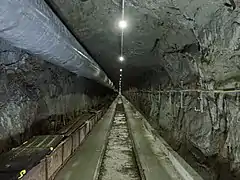 Tunnel de Bedretto (ici dans le Granite du Rotondo) après aménagements pour le laboratoire (ventilation, câbles, éclairage). À noter que le tunnel est sans revêtement sur la majeure partie.