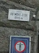 Plaque posée à l'entrée du tunnel où il y est écrit « Tunnel du mont-d'Or 6115 m ».