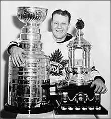 Joueur de hockey posant avec deux trophées