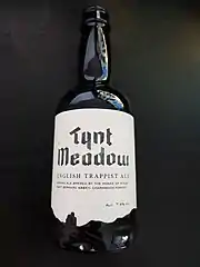 Photographie d'une bouteille de bière dont l'étiquette porte la mention « Tynt Meadow » en une police de facture médiévale.