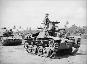 Photo en noir et blanc de deux chars de combat, un homme est debout sur le premier.