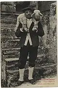 Photographie en noir et blanc d'un homme portant un agneau sur ses épaules.