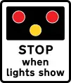 Avertissement des signaux lumineux à un passage à niveau sans une porte ou une barrière à l'avance (le signe peut aussi être utilisé à un pont de levage ou de l'aérodrome)