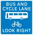 Voie de bus contre le trafic que les vélos peuvent aussi utiliser avec le trafic approchant de la droite (avertissement pour les piétons)
