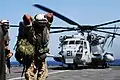 Un hélicoptère CH-53 Super Stallion de l'US Marine Corps s'apprête à décoller du pont d'envol de l'USS Gunston Hall en mer Rouge.
