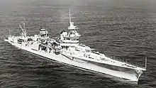 Photo en noir et blanc d'un croiseur vu de trois-quart tribord avant