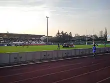 Deux groupes de joueurs de rugby entrent en mêlée sur la pelouse d'un stade.