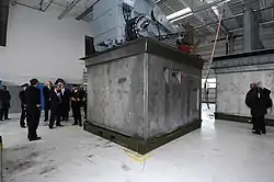 Le conteneur StanFlex portant le sonar tracté à immersion variable exposé dans un hangar devant des officiers
