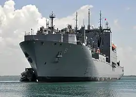 Photographie en couleur d'une imposante proue de navire militaire.