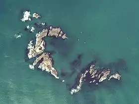 Vue aérienne du récif d'Ubashima (Eboshi-iwa), où apparaissent les nombreux rochers qui le composent (photographie de 1977, fournie par le ministère du Territoire, des Infrastructures, des Transports et du Tourisme du Japon, 国土航空写真).