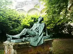 Vue d'une statue représentant un soldat presque allongé, appuyé sur ses bras.