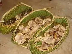 Photographie des paniers tressés contenant les légumes, sur lesquels sont ensuite déposés les cochons.