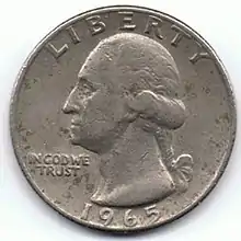 Revers d'une pièce de monnaie comportant la tête d'un homme tournée vers la gauche et des inscriptions.
