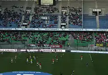 Photo montrant la tribune d'un stade de football, et deux banderoles dans sa partie inférieure