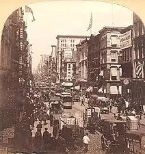 Photographie ancienne sépia d'une rue très encombrée.