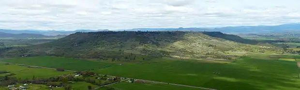 Vue d'un relief tabulaire entouré de champs.