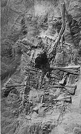 Photographie en noir et blanc de ruines disposées selon un plan orthogonal.
