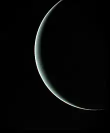Uranus apparaissant comme un fin croissant lumineux devant un fond noir.