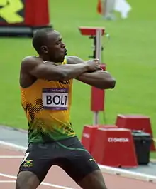 Photographie de Usain Bolt, bras croisés, à l'arrivée des séries du 200 m