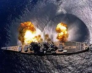 Le cuirassé américain USS Iowa tirant une bordée de ses 3 pièces triples de 406 mm.