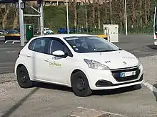 Photographie en couleurs représentant une voiture blanche.